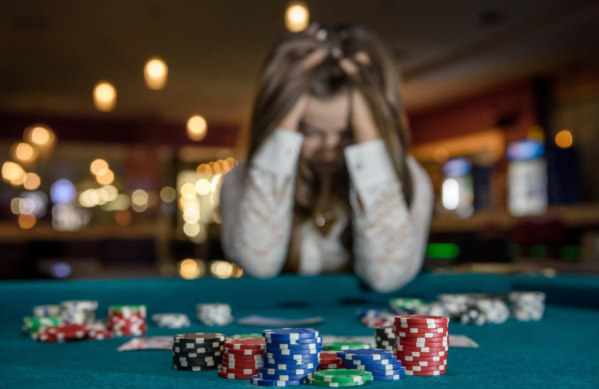 Girl holding her head after losing a poker hand