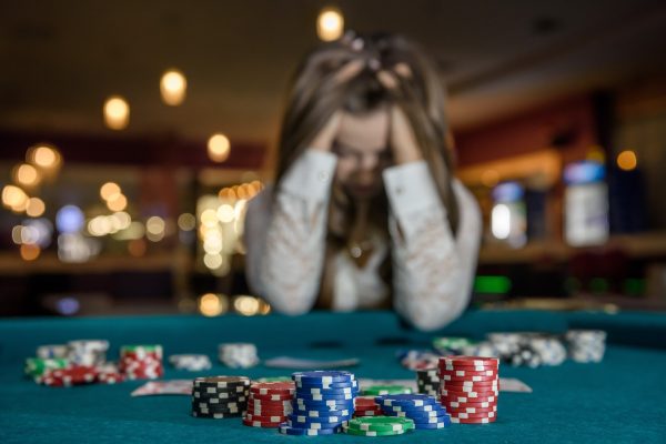 Girl holding her head after losing a poker hand