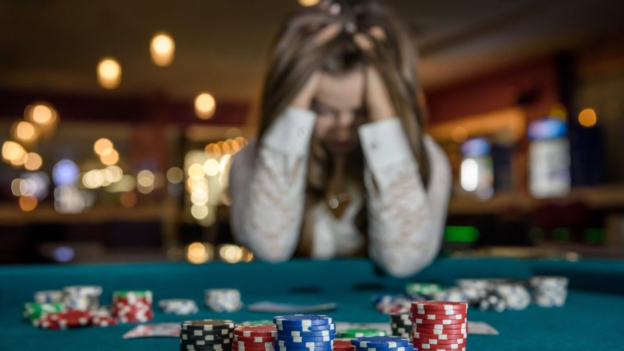 Girl holding her head after losing a poker hand