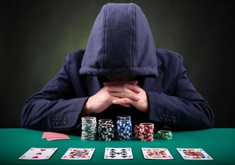 man with hoodie on face down looking at his chips