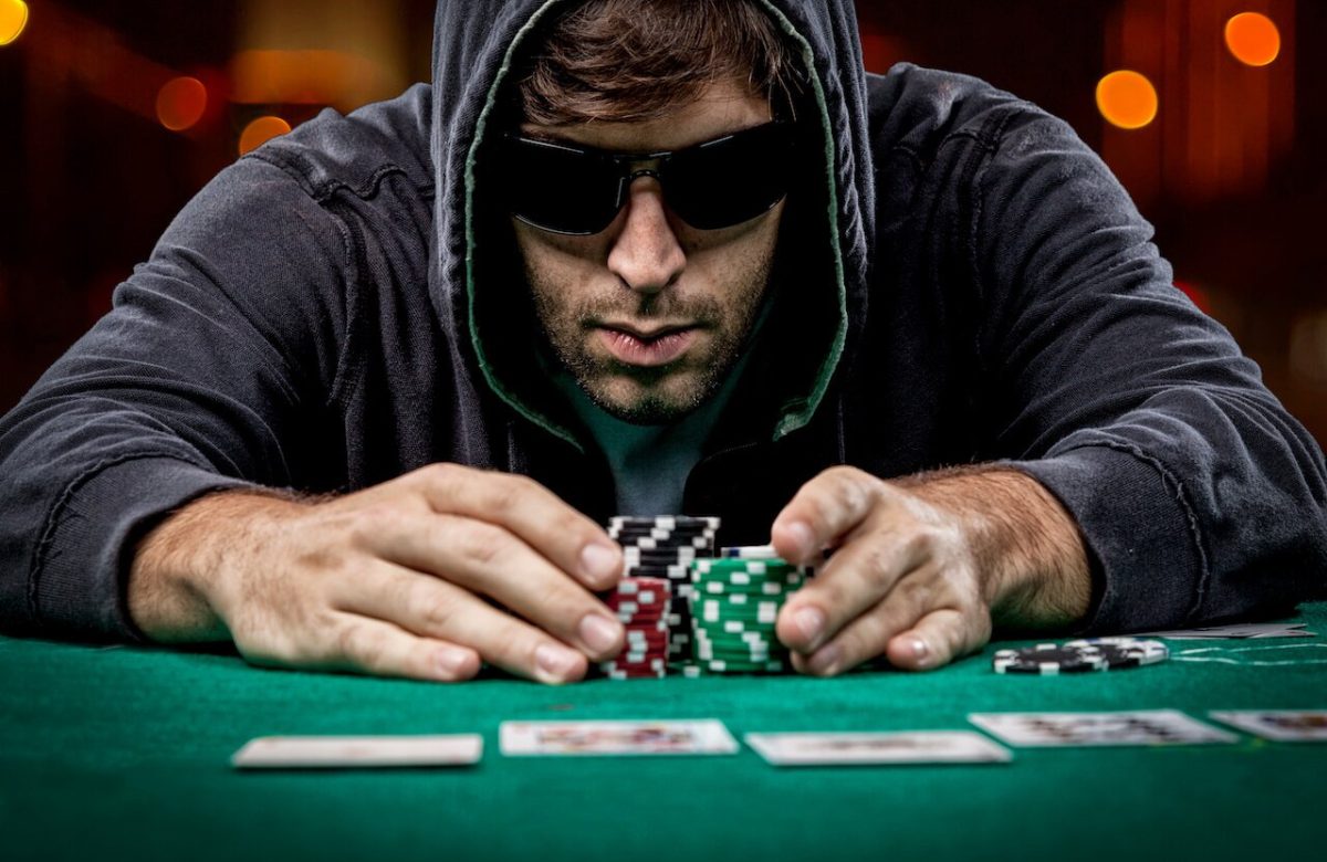 Ma with sunglasses pushing chips in the middle of the table