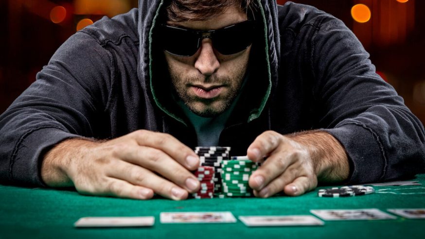 Ma with sunglasses pushing chips in the middle of the table