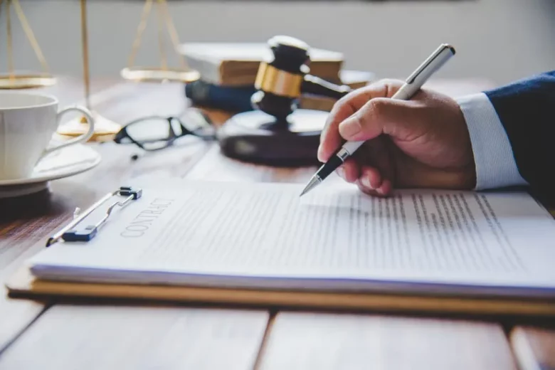 A judge writing with a pen on a contract paper