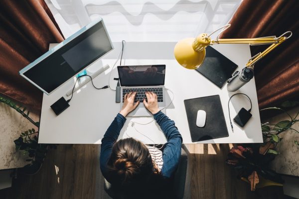 woman on computer with birds eye view of desk