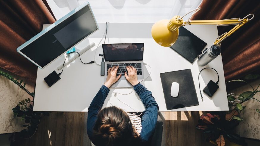 woman on computer with birds eye view of desk