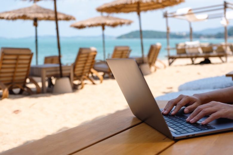 laptop on the beach with beach chairs around