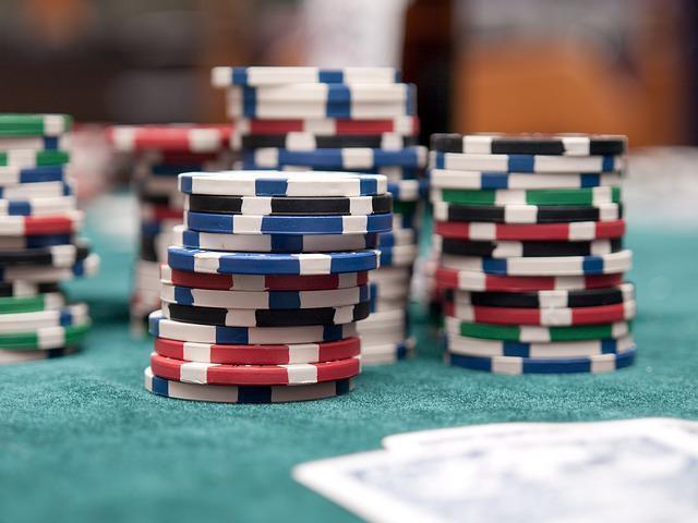Mixed stacks of poker chips in front of two cards