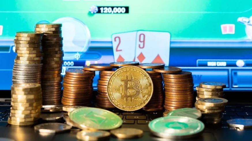 A bitcoin in front of a stack of coins and an online poker site