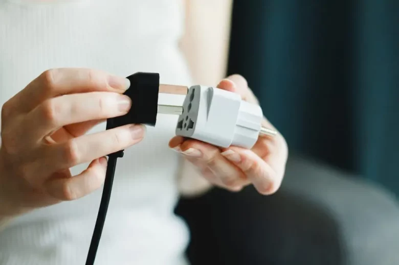 A person putting a port into a travel adapter 