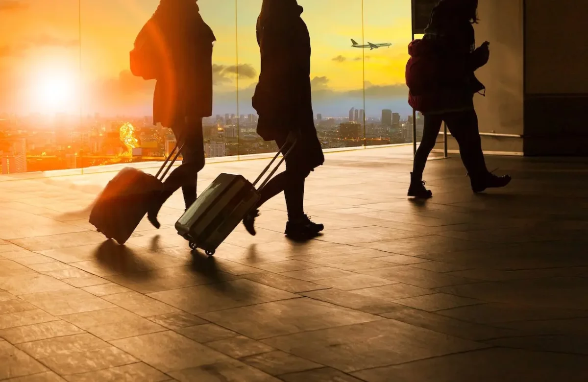 two people rolling their bags through an airport