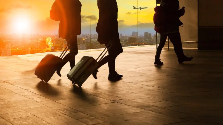 two people rolling their bags through an airport