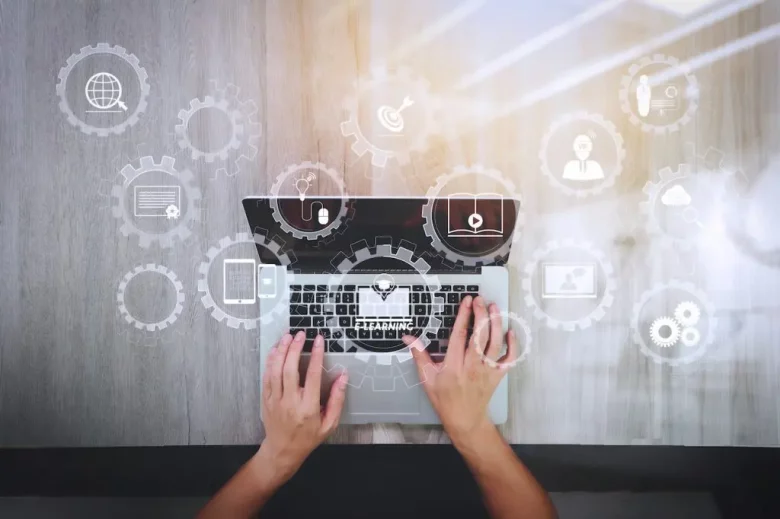 Someone with a laptop with a bunch of icons around it