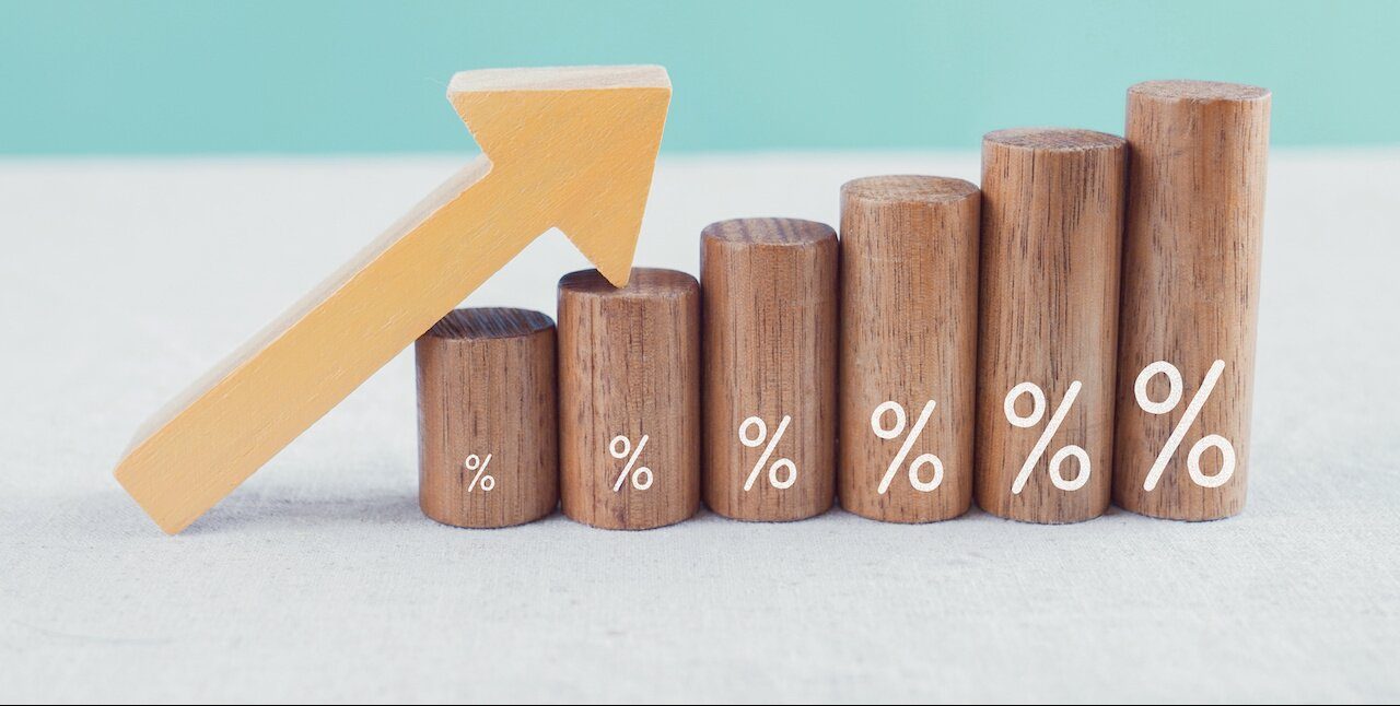 Wooden blocks with percentage sign and arrow up, financial growth, interest rate and mortgate rate increase, inflation concept