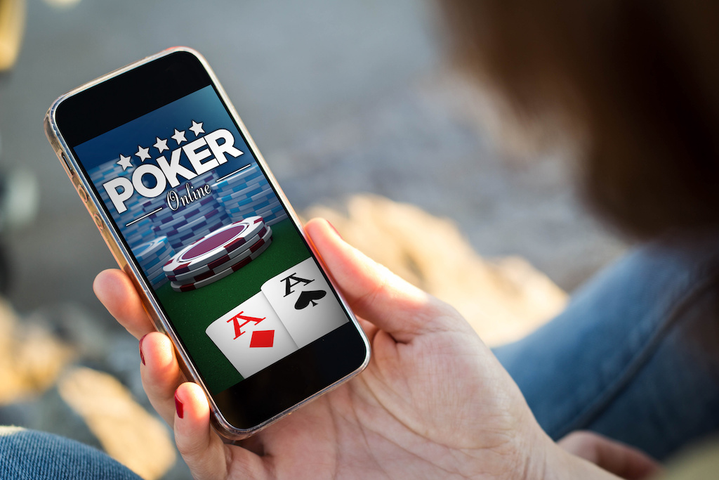 close-up view of young woman playing poker on her mobile phone. All screen graphics are made up.