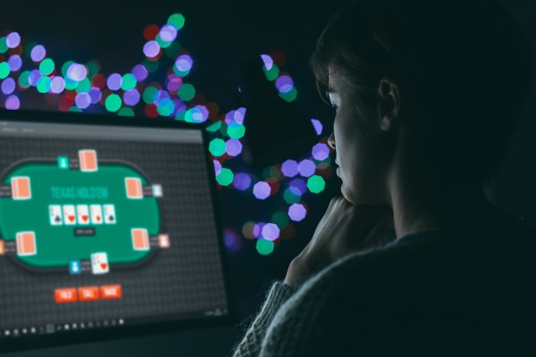Woman playing online poker late at night, games and gambling concept