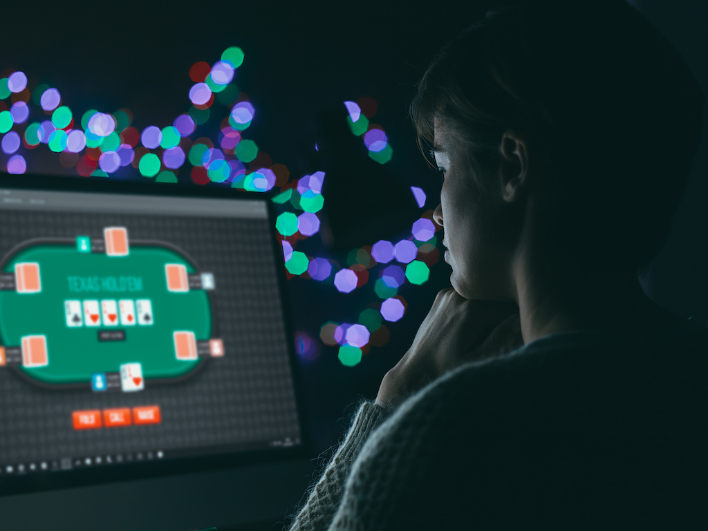 Woman playing online poker late at night, games and gambling concept