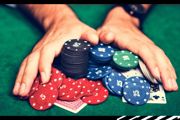 Hands with Poker chips playing Texas Hold'em Poker.