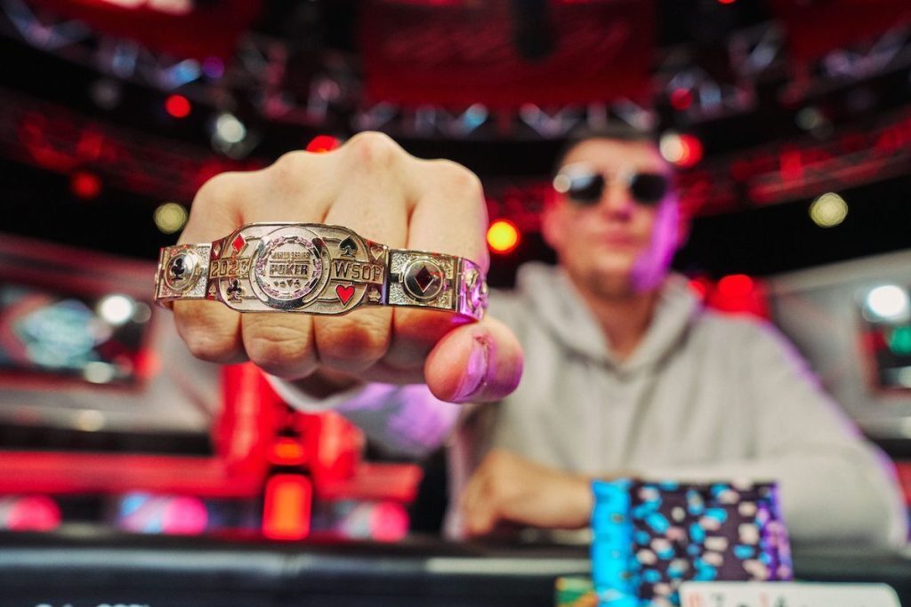 Jesse Lonis holding his WSOP bracelet with a closeup shot