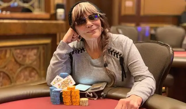 Barbara Enright wearing sunglasses and playing poker in front of a stack of chips