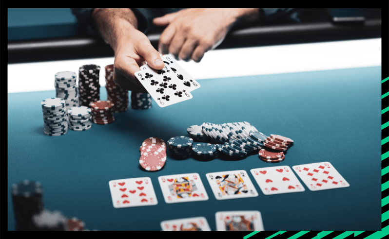 Cards being displayed on a poker table with poker chips stacked.