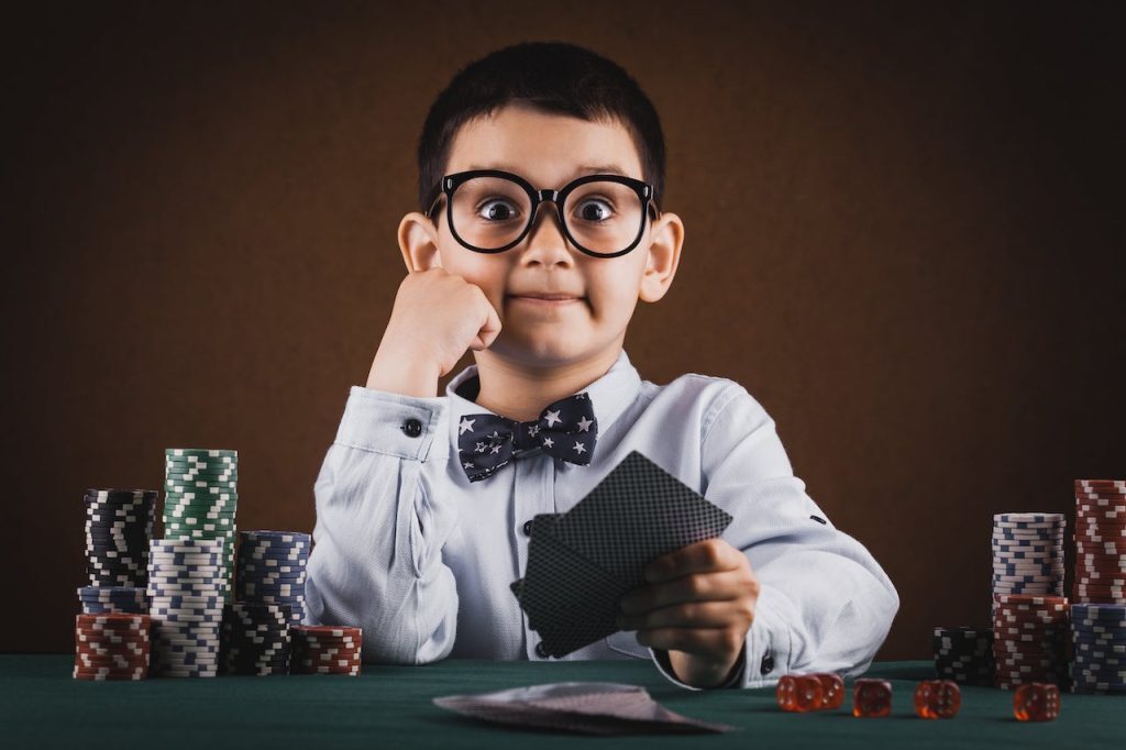 a child handling cards and playing poker