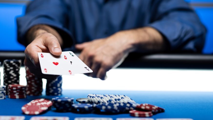 A poker player turning up a pair of aces after making a bet