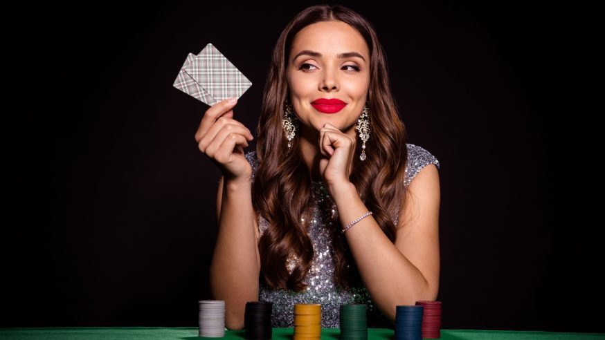 A woman holding a poker hand and thinking about her decision,